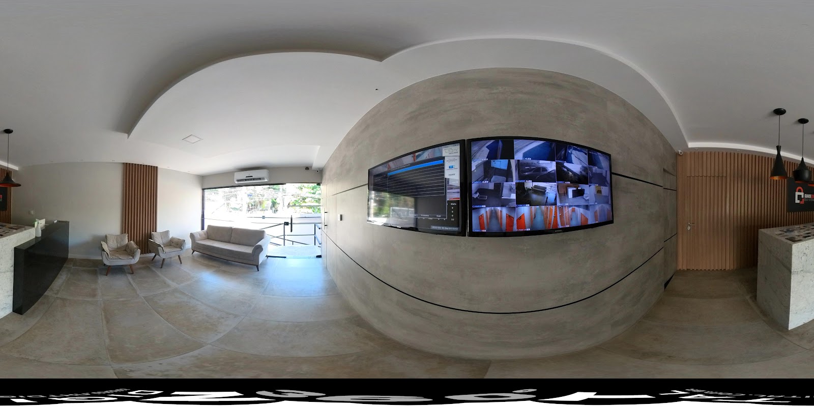 Lounge interno com painel de câmeras de segurança 24h